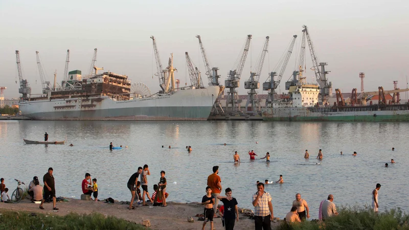 Fotografija: Iračani se hladijo ob reki Šat al Arab Shatt, v bližini pristanišča pri mestu Basra. FOTO: Hussein Faleh/Afp