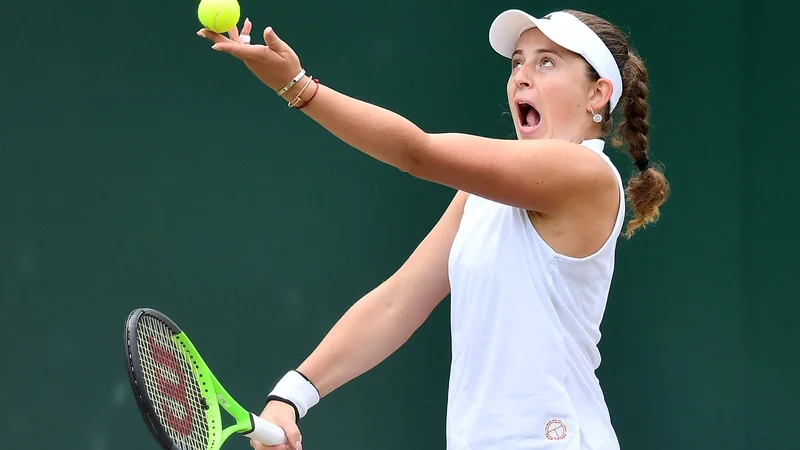 Fotografija: Jelena Ostapenko med začetnim udarcem na obračunu z Ajlo Tomljanović v Wimbledonu, kjer so besede odmevale bolj kot udarci z loparjem. FOTO: Ben Stansall/AFP