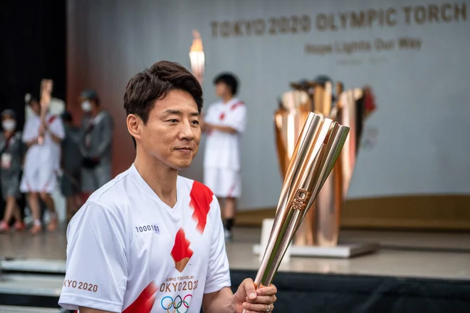 Olimpijski plamen je v Tokiu pomagal nositi tudi nekdanji teniški igralec Šuzo Macuoka. FOTO: Philip Fong/AFP