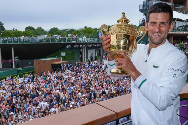 Novak Đoković je ponosno predstavil občinstvu pred vhodom na osrednje igrišče svojo šesto wimbledonsko lovoriko. FOTO: Bob Martin/AFP