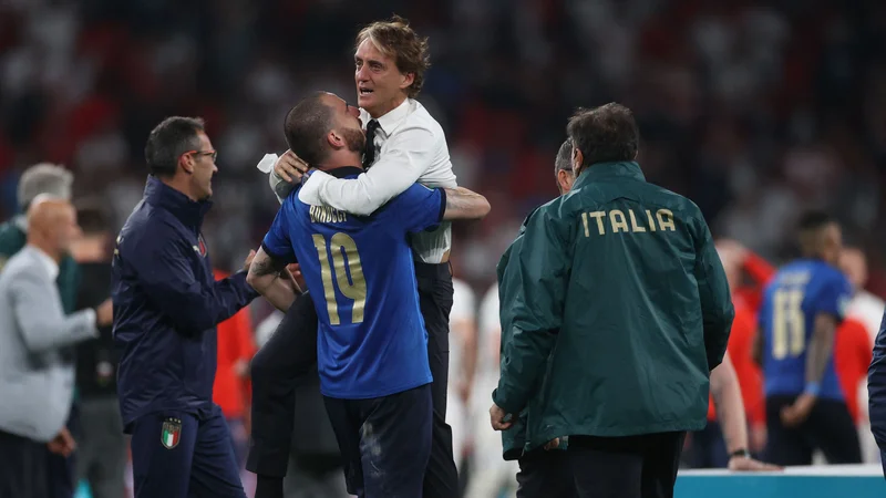 Fotografija: Mancini proslavlja s strelcem italijanskega gola za izenačenje Leonardom Bonuccijem. FOTO: Carl Recine/AFP