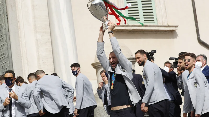 Fotografija: Kapetan Giorgio Chiellini je mahal s pokalom ob prihodu na sprejem k predsedniku. Foto Remo Casilli/Reuters