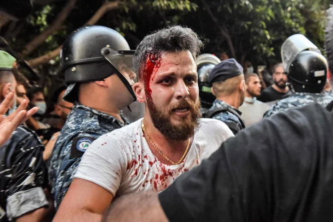 Na protestu pred rezidenco libanonskega ministra za notranje zadeve v soseski Qoraitem v zahodnem Bejrutu je policija proti demonstrantom in družinam žrtev lanske eksplozije uporabila fizično silo in solzivec. Narod za hudo eksplozijo, ki se je zgodila 4. avgusta lani, krivi notranjega ministra Mohammada Fahmija. FOTO: Anwar Amro/Afp<br />
