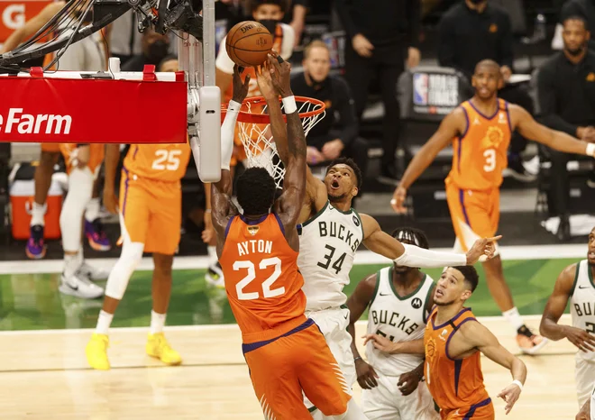 Giannis Antetokounmpo (34) in Deandre Ayton (22) sta bila hude bitke pod košema. FOTO: Jeff Hanisch/Usa Today Sports