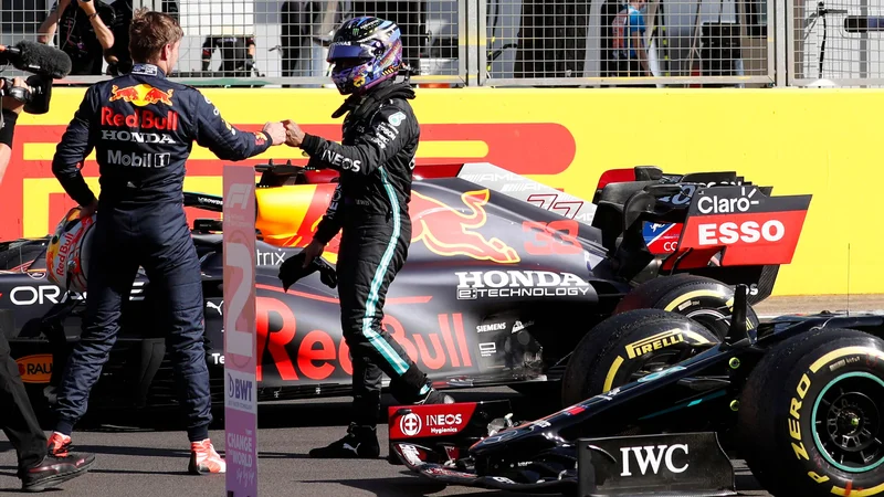 Fotografija: Pozdrav najhitrejših: Verstappen (levo) in Lewis Hamilton po kvalifikacijah v Silverstonu. FOTO: Adrian Dennis/AFP