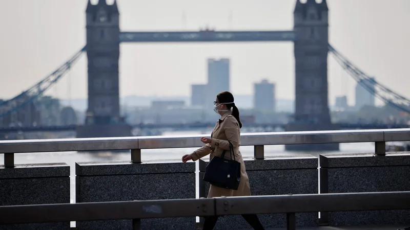 Fotografija: Kljub temu da je Anglija zaradi visoke precepljenosti ukinila skoraj vse omejitve, v Londonu še vedno srečamo ljudi z zaščitno masko. Foto Tolga Akmen/AFP