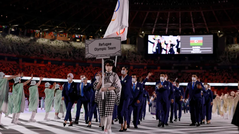 Fotografija: Begunska ekipa med današnjo slovesnostjo ob začetku iger v Tokiu. FOTO: Odd Andersen/AFP