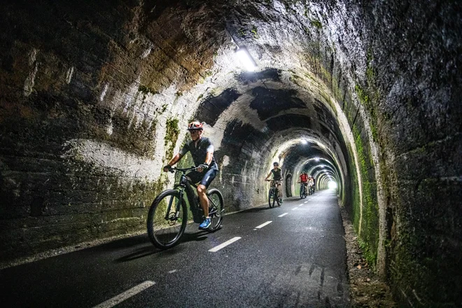 V temini 500 metrov dolgega predora, kjer je nekoč vodila ozkotirna železnica, danes pa se skoznjo prebijajo kolesarji. FOTO: Jošt Gantar