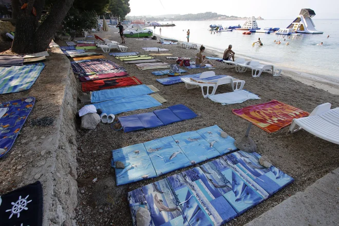Tako si dopustniki z brisačami in ležalniki zgodaj zjutraj rezervirajo mesto na plaži v Makarski. Foto Ivo Ravlić/Cropix