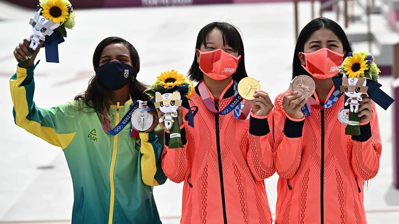 Fotografija: Po tekmovanju je ob Mimidži Nišiji na eni strani stala dobitnica srebrne medalje, prav tako 13-letna Brazilka Rayssa Leal, na drugi strani pa samo tri leta starejša Japonka Funa Nakajama. To je bil najmlajši zmagovalni oder v zgodovini olimpijskih iger. FOTO: Jeff Pachoud/AFP