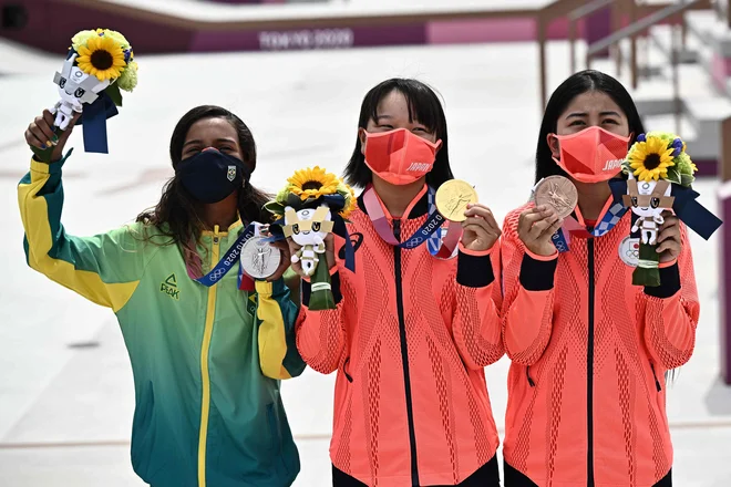 Po tekmovanju je ob <strong>Mimidži Nišiji </strong>na eni strani stala dobitnica srebrne medalje, prav tako 13-letna Brazilka <strong>Rayssa Leal</strong>, na drugi strani pa samo tri leta starejša Japonka <strong>Funa Nakajama</strong>. To je bil najmlajši zmagovalni oder v zgodovini olimpijskih iger. FOTO:&nbsp;Jeff Pachoud/AFP