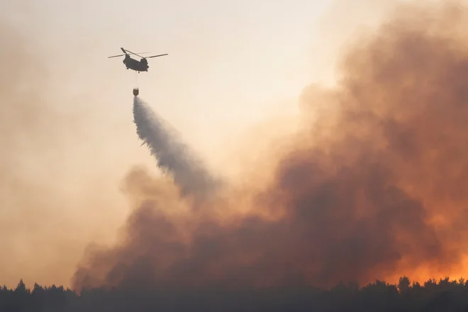 Z ognjem se bori okoli 500 gasilcev, pomaga jim pet helikopterjev in na desetine letal. FOTO: Giorgos Moutafis/Reuters