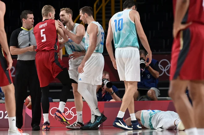 Nemci niso izbirali prijemov pri spremljanju Luke Dončića (na tleh) in v bran mu je moral stopiti tudi mirni Jaka Blazič (11). FOTO: Aris Messinis/AFP