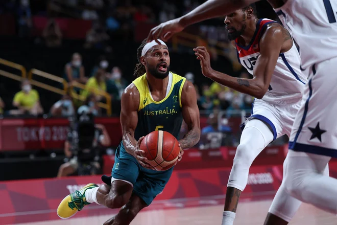 Spretni Patty Mills (z žogo) je bil trd oreh tudi za Kevina Duranta (desno). FOTO: Thomas Coex/AFP
