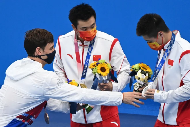 Daley (levo) v pogovoru z Jianom,&nbsp;ki je pomotoma prejel maskoto, namenjeno zmagovalcu. FOTO: Attila Kisbenedek/AFP