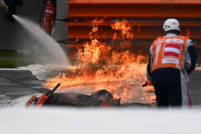 Lorenzo Savadori in Dani Pedrosa sta trčila, njuna motorja sta zagorela. FOTO: Joe Klamar/AFP