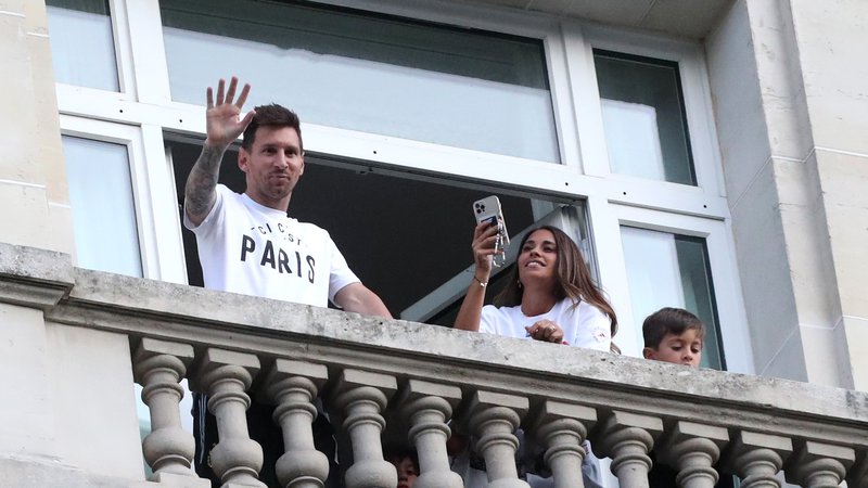 Fotografija: Lionel Messi in Antonella sta takole pomahala navijačem iz pariškega hotela Royal Monceau Hotel. FOTO: Yves Herman/Reuters