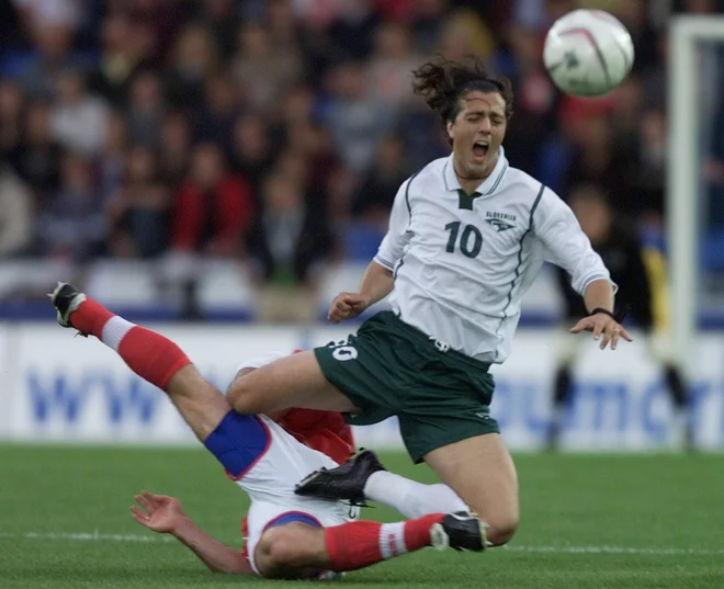 Zlatko Zahovic (R) of Slovenia falls over Yvan Quentin of Switzerland (L) during their World Cup 2002 European group one qualifier in the St.-Jakob-Park in Basle June 6, 2001.    REUTERS/Ruben Sprich