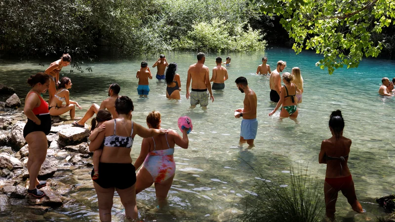Fotografija: Turisti v Španiji se te dni hladijo v jezeru. FOTO: Jon Nazca/Reuters