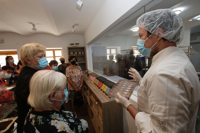 Tomaž skupinam obiskovalcev rad predstavi sladko proizvodnjo. FOTO: Jože Pojbič/Delo
