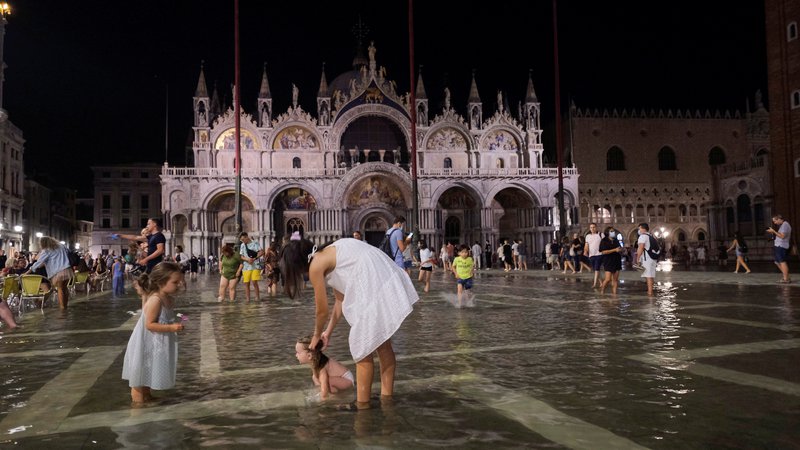 Fotografija: People walk in a flooded St. Mark's Square during an exceptional high water in Venice, Italy August 8, 2021. Picture taken August 8, 2021. REUTERS/Manuel Silvestri Foto Manuel Silvestri Reuters