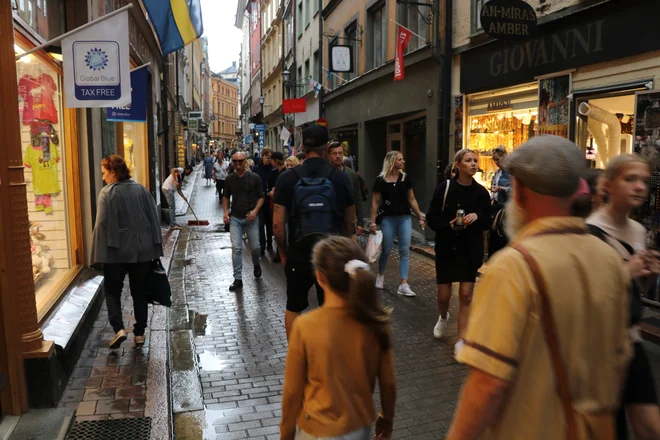 Večerna gneča brez mask v eni od nakupovalnih uličic v starem središču Stockholma Gamla Stanu. FOTO: Jože Pojbič