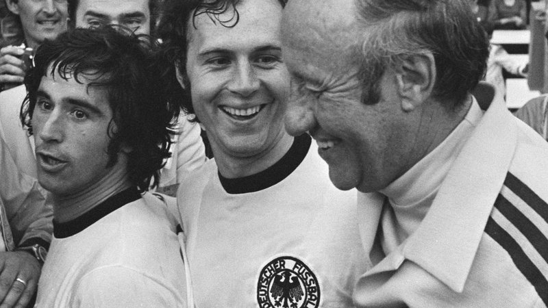 Fotografija: Gerd Müller, Franz Beckenbauer in selektor Helmut Schön po zmagi na svetovnem prvenstvu leta 1974. Foto Wikipedia