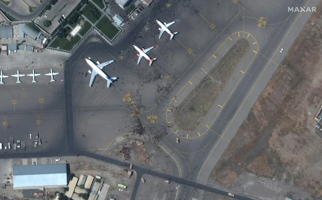Z letališča so ves dan prihajali dramatični posnetki z množico ljudi na prostoru, kjer so parkirana letala za izkrcanje in vkrcanje potnikov.&nbsp;FOTO: Maxar Technologies/AFP