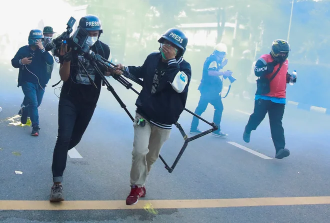 Predstavniki medijev bežijo pred solzivcem, ki ga je med protivladnim protestom v Bangkoku policija uporabila proti demonstrantom. FOTO: Soe Zeya Tun/Reuters