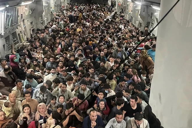 Ameriški vojaški pilot je na kabulskem letališču v tovorno letalo, ki naj bi sprejelo največ 150 ljudi, natlačil več kot 600 potnikov. FOTO: Kap. Chris Herbert/zračne sile ZDA/AFP