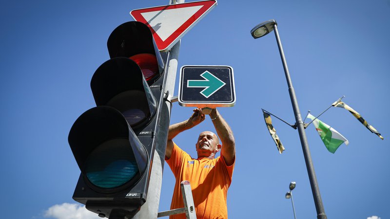 Fotografija: Postavljanje prvega prometnega znaka za zavijanje desno pri rdeči luči na semaforju. FOTO: Jože Suhadolnik/Delo