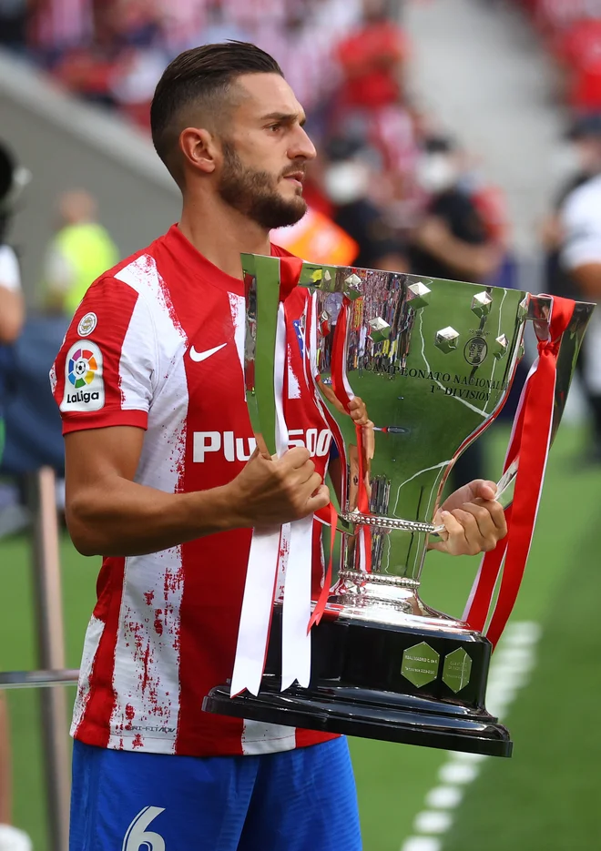Rojeni Madridčan Koke, prihaja sicer iz četrti, kjer leži štadion prvoligaškega tekmeca Raya Vallecana, je na Wando prinesel maja letos osvojeno trofejo. Proslava je po takratnem povratku iz Valladolida, kjer so rdeče-beli potrdili osvojitev naslova, potekala pred praznimi tribunami domačega štadiona, kjer se je tokrat zbralo okoli 20.000 gledalcev. FOTO: Juan Medina/Reuters