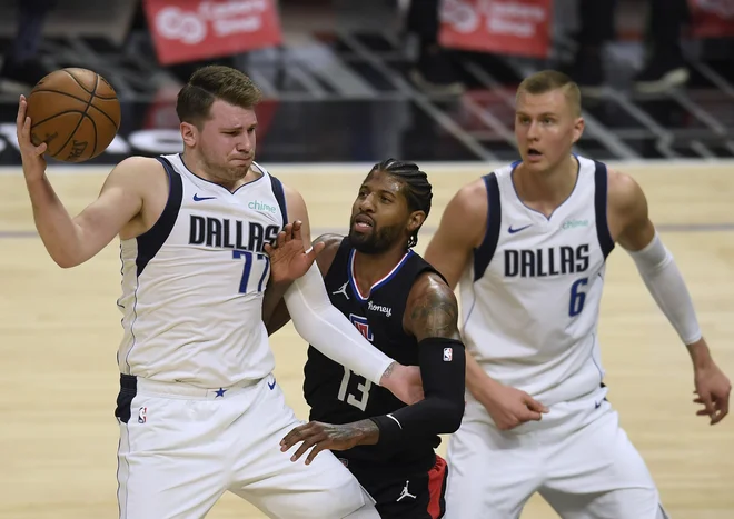 Porzingis (desno) je ob Luku Dončiću v minuli sezoni iz tedna v teden igral manj. FOTO: Harry How/AFP
