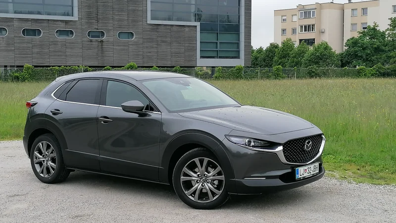 Fotografija: Mazda CX30 je kompaktni mestni terenec z izrazito široko masko in ozkimi žarometi ter valovito mehko obliko. Testni primerek je pravo vrednost skrival pod motornim pokrovom. FOTO: Boštjan Okorn