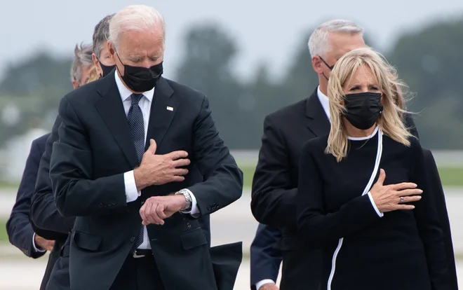 Predsednika Joeja Bidna so napadli tudi zaradi pogledovanja na uro med slovesnostjo za padle ameriške vojake. FOTO: Saul Loeb/Afp