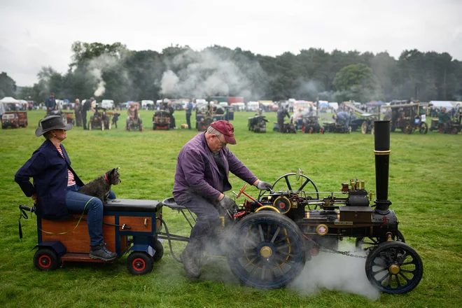 Moški vozi miniaturni parni stroj na sejmu »Yorkshire Traction Engine Rally« v Maltonu blizu Yorka, na severu Anglije. Na sejmu, ki je potekal 4. in 5. septembra, je bilo poleg vojaških in klasičnih vozil moč videti tudi delujoče parne stroje. FOTO: Oli Scarff/Afp<br />
<br />
