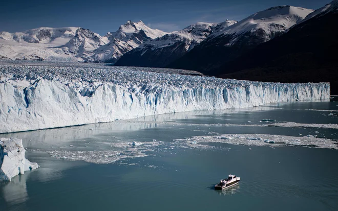 Turisti si z ladjo ogledujejo Perito Moreno, največji ledenik na svetu, ki se nahaja v argentinskem nacionalnem parku Los Glaciares. FOTO: Ronaldo Schemidt/Afp