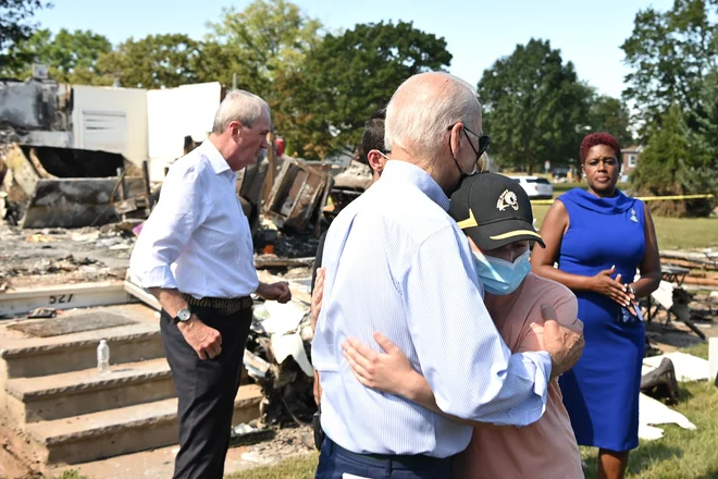 Ameriški predsednik Joe Biden objema osebo, med obiskom soseske v New Jerseyju, ki jo je prizadel orkan Ida. Biden se je v torek odpravil v New York in New Jersey, ki ju je opustošil orkan Ida le nekaj dni po pregledu škode, ki jo je orkan Ida povzročil v Louisiani. Biden, ki verjame v zeleno gospodarstvo trdi, da je ekstremno vreme v ZDA to poletje napovednik hujših podnebnih sprememb, ki prihajajo. FOTO: Mandel Ngan/Afp