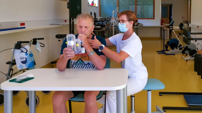 Fotografija: Najhuje bolni imajo po prebolelem covidu zgolj polovično zmogljivost pljuč; krepijo si jo z respiratorno fizioterapijo. Na fotografiji bolnik Vladimir Furman in fizioterapevtka Bernarda Hafner v URI Soča. FOTO: Milena Zupanič