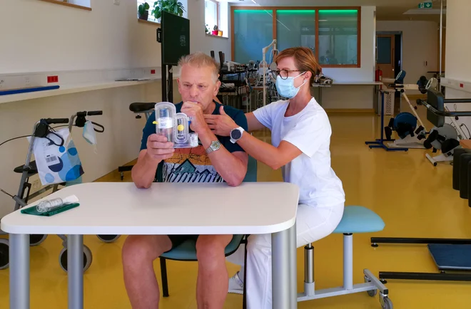 Najhuje bolni imajo po prebolelem covidu zgolj polovično zmogljivost pljuč; krepijo si jo z respiratorno fizioterapijo. Na fotografiji bolnik Vladimir Furman in fizioterapevtka Bernarda Hafner v URI Soča. FOTO: Milena Zupanič