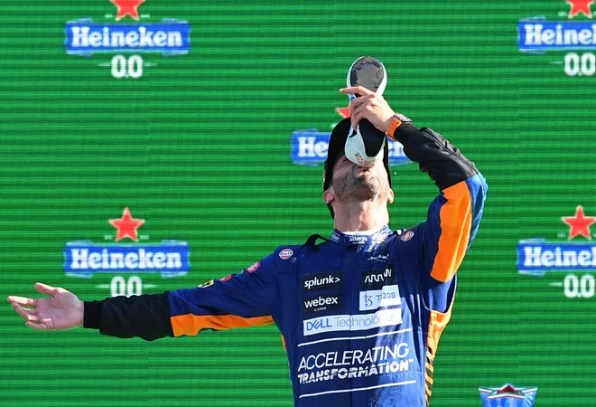 Daniel Ricciardo je zmago proslavil v svojem značilnem slogu – s pitjem šampanjca iz svojega (preznojenega) športnega copata. FOTO: Jennifer Lorenzini/Reuters