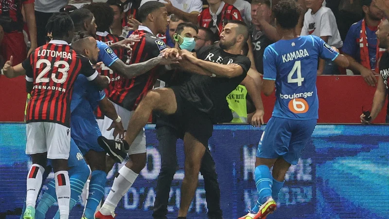 Fotografija: Payet (spodaj levo v modrem dresu) se je moral braniti pred jeznimi navijači Nice. FOTO: Valery Hache/AFP