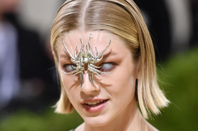 Portret ameriške manekenke Hunter Schafer na modnem dogodku Met Gala v newyorškem muzeju umetnosti Metropolitan. Letošnji Met Gala je imel izrazito mladosten pečat, saj so ga gostili pevka Billie Eilish, igralec Timothee Chalamet, pesnica Amanda Gorman in teniška zvezdnica Naomi Osaka, od katerih noben ni starejši od 25 let. Tema leta 2021 je »In America: A Lexicon of Fashion«. FOTO: Angela Weiss/Afp<br />
