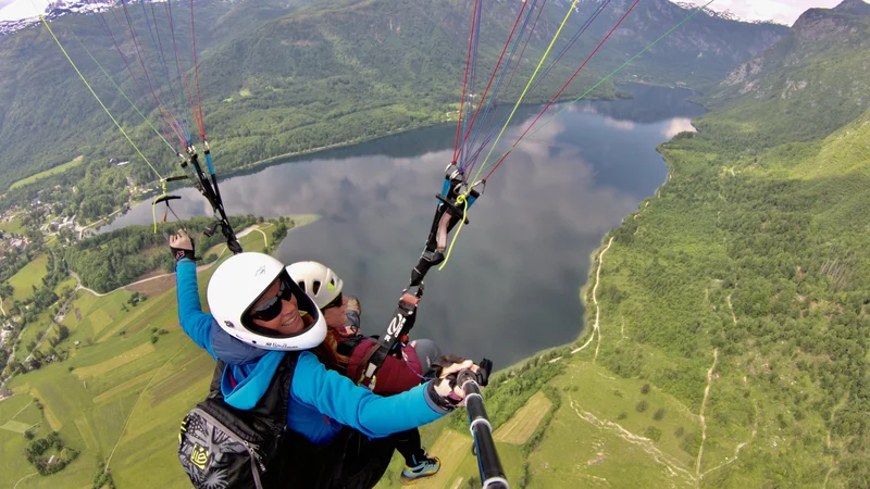 Fotografija: Dih jemajoč polet z Vogarja je tudi precej brezskrben za sopotnika v tandemu. Vse izkušnje in znanje morajo namreč imeti licencirani piloti. FOTO: Loopteam