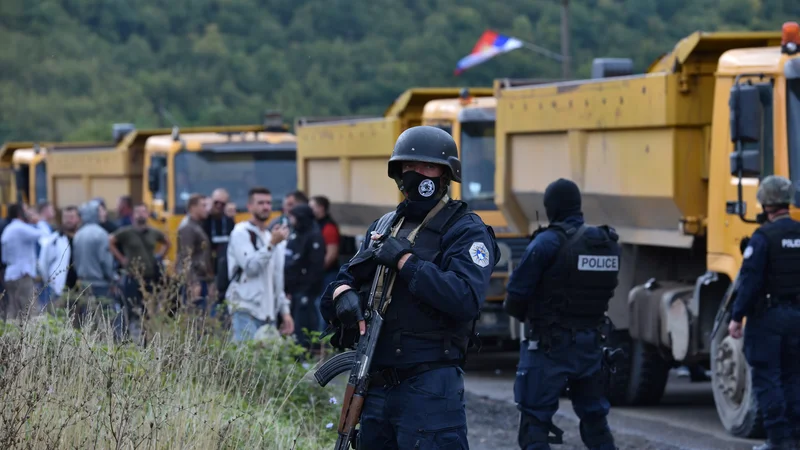 Fotografija: Specialne enote kosovske policije nadzirajo srbske protestnike, ki so s tovornjaki onemogočili dostop do mejnega prehoda med Kosovom in Srbijo. Foto Laura Hasani Reuters