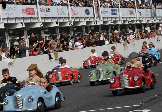 Otroci dirkajo z avtomobili na pedala na pokalu Settrington Cup, ki je potekal v okviru tridnevnega zgodovinskega dirkalnega festivala Goodwood Revival v Goodwoodu na jugu Britanije. FOTO: Toby Melville/Reuters<br />
