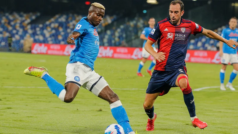 Fotografija: Victor Osimhen (levo) med dvobojem z Diegom Godinom in Cagliarijem na štadionu Diega Maradone. Napoli je slavil z 2:0. FOTO: Carlo Hermann/AFP