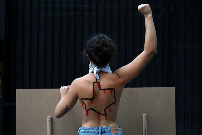 Članica aktivistične skupine Femen z narisano ameriško zvezno državo Teksas na hrbtu, je pred ameriškim konzulatom v Madridu protestirala proti novemu zakonu o splavu v Teksasu. Teksaški guverner je pohvalil nov zakon o splavu, ki zaostruje zakon o zdravilih, ki povzročajo splav. To ustvarja dodatne omejitve po skoraj popolni prepovedi splava. Nove omejitve, ki začnejo veljati decembra 2021, skrajšajo čas, ko lahko zdravniki v Teksasu predpišejo zdravila, ki povzročajo splav in prepoveduje dostavo tablet po pošti. FOTO: Gabriel Bouys/Afp<br />
