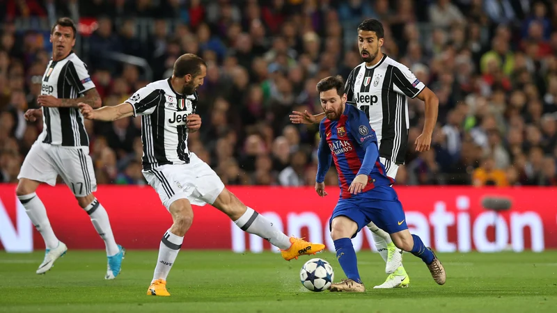 Fotografija: Argentinski kapetan Lionel Messi (desno) v boju z italijanskim Giorgiem Chiellinijem na tekmi lige prvakov med Barcelono in Juventusom. FOTO: Albert Gea/Reuters