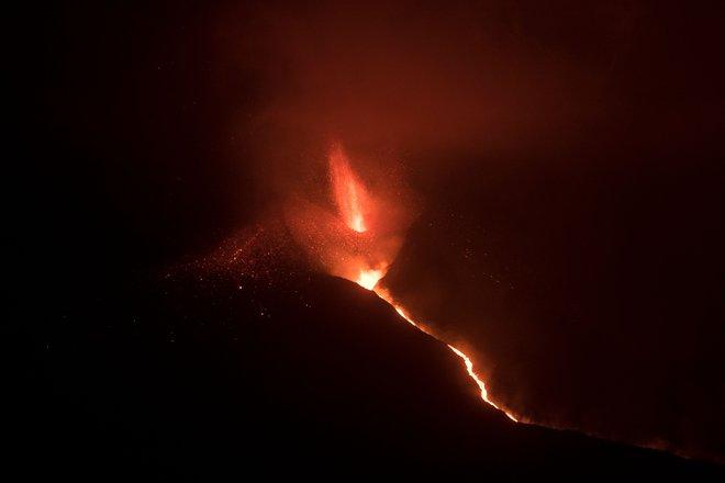 Iz vulkana Cumbre Vieja, ki je izbruhnil 19. septembra, se je v torek še vedno vila reka lave, ki je prejšnji teden dosegla Atlantski ocean. FOTO: Jorge Guerrero/AFP